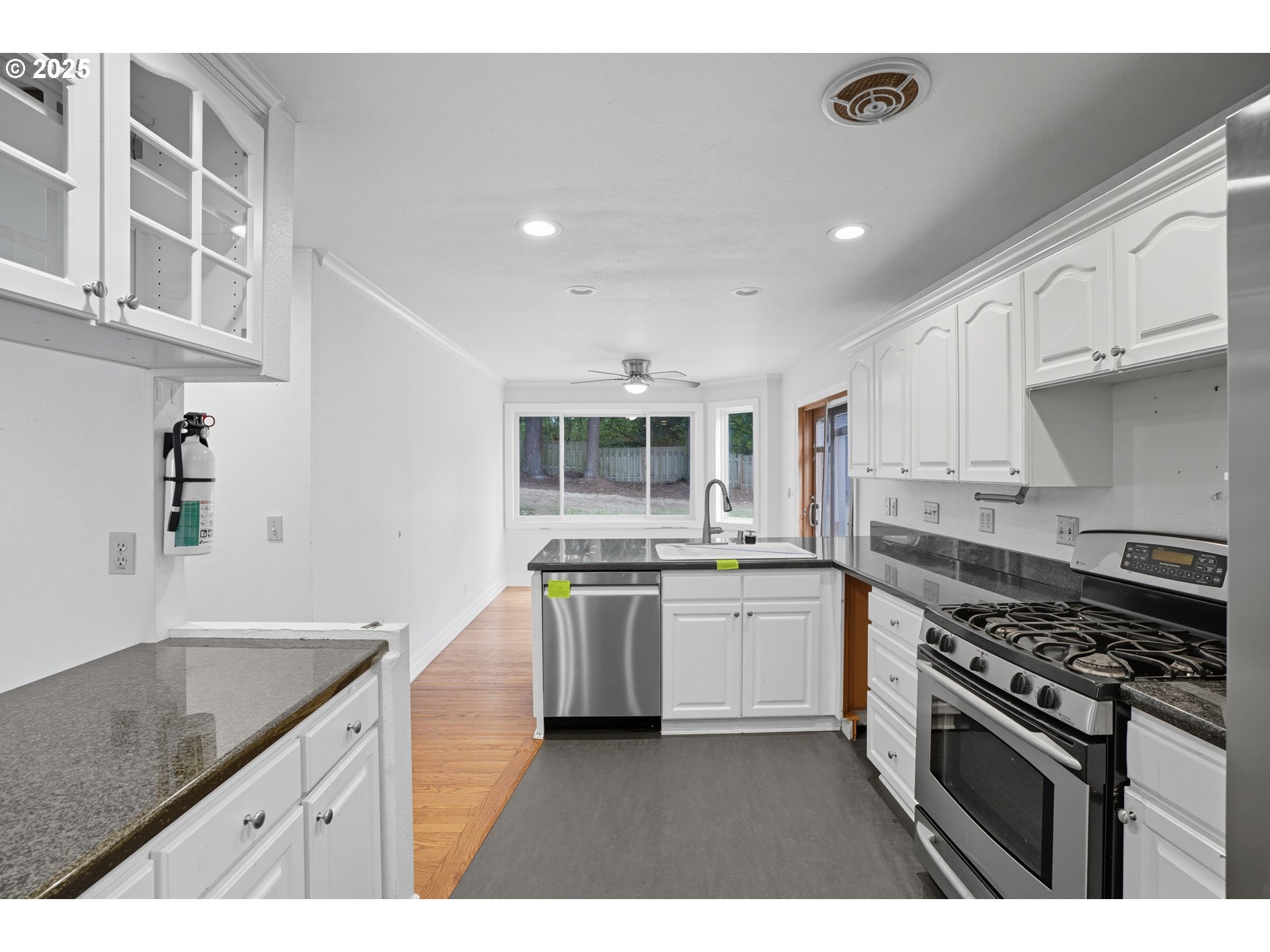9360 Southwest Meadow Lane Portland, OR 97225 - Photo 11 of 48 a kitchen with stainless steel appliances granite countertop a stove and a sink