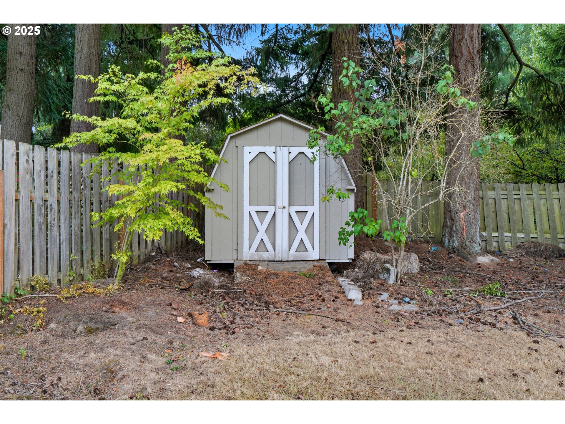 9360 Southwest Meadow Lane Portland, OR 97225 - Photo 35 of 48 a view of a grey house with a yard and large trees