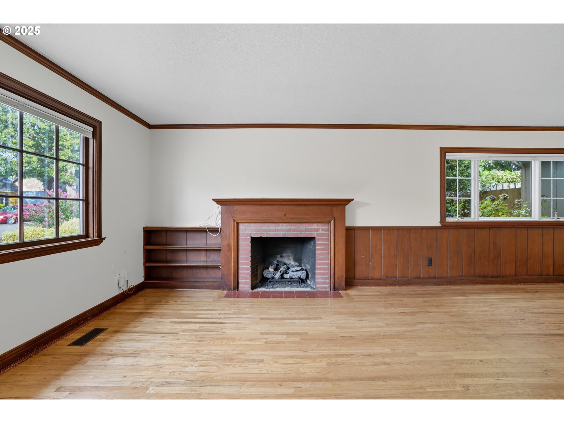 9360 Southwest Meadow Lane Portland, OR 97225 - Photo 8 of 48 a view of an empty room with wooden floor fireplace and a window