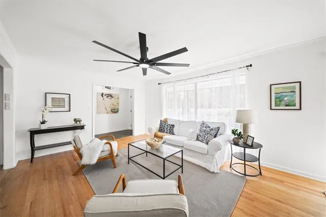 a living room with furniture and a wooden floor