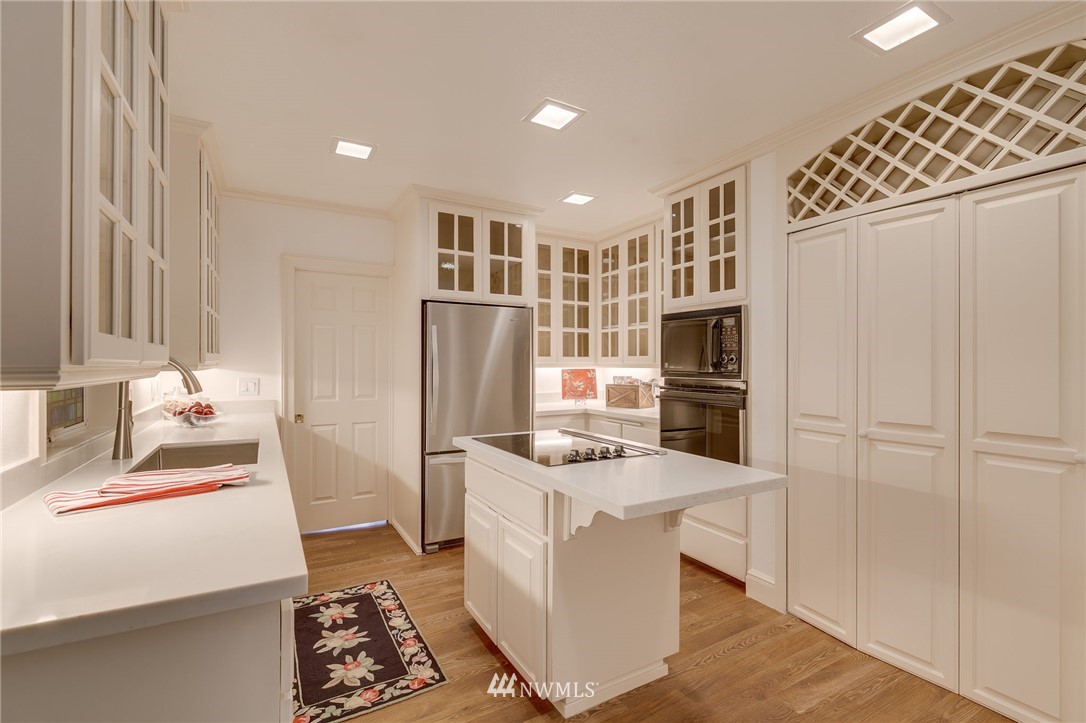611 Newberg Road Snohomish, WA 98290 - Photo 15 of 40 a kitchen with stainless steel appliances kitchen island granite countertop a refrigerator a stove and a sink with wooden floor