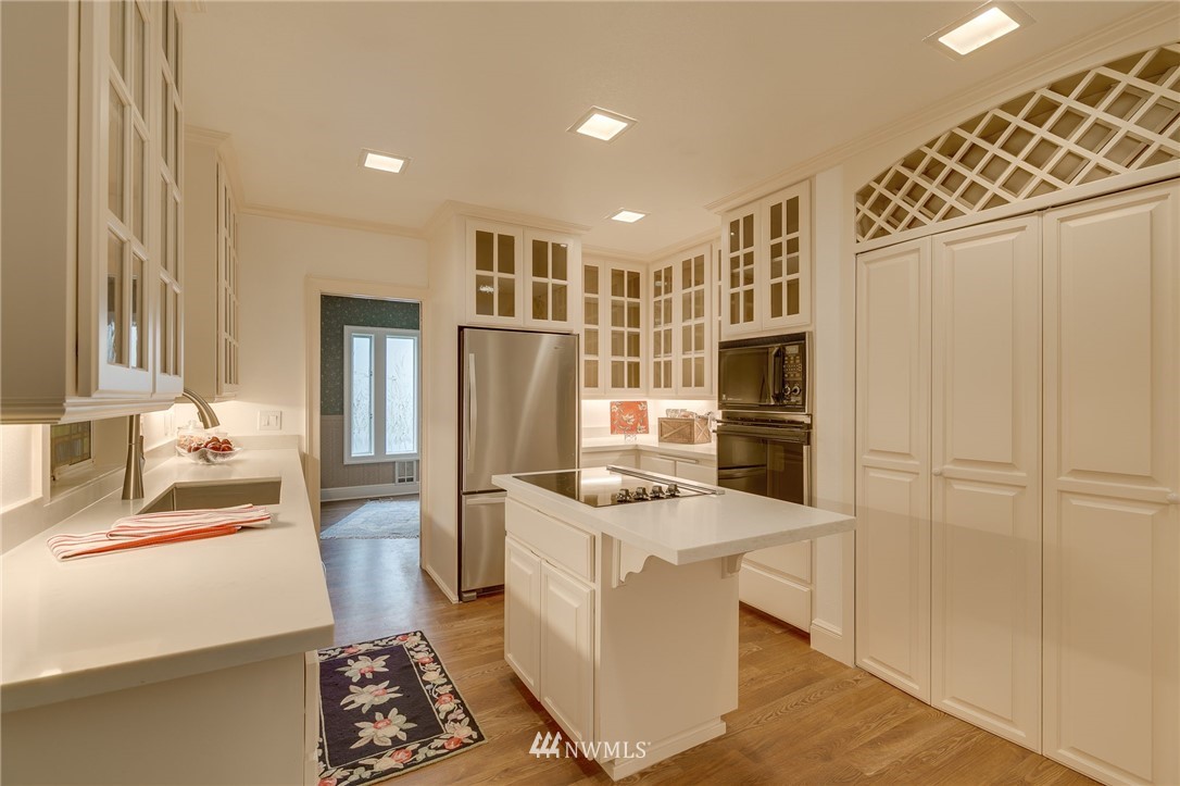611 Newberg Road Snohomish, WA 98290 - Photo 16 of 40 a kitchen with stainless steel appliances kitchen island granite countertop a refrigerator a stove and a sink with wooden floor