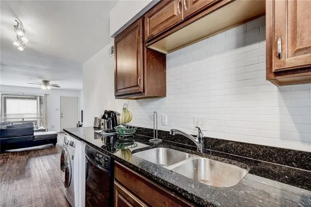 a kitchen with granite countertop stainless steel appliances a sink stove and cabinets
