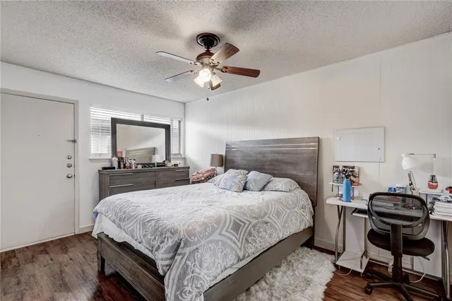 a bedroom with a bed a chandelier and a dresser