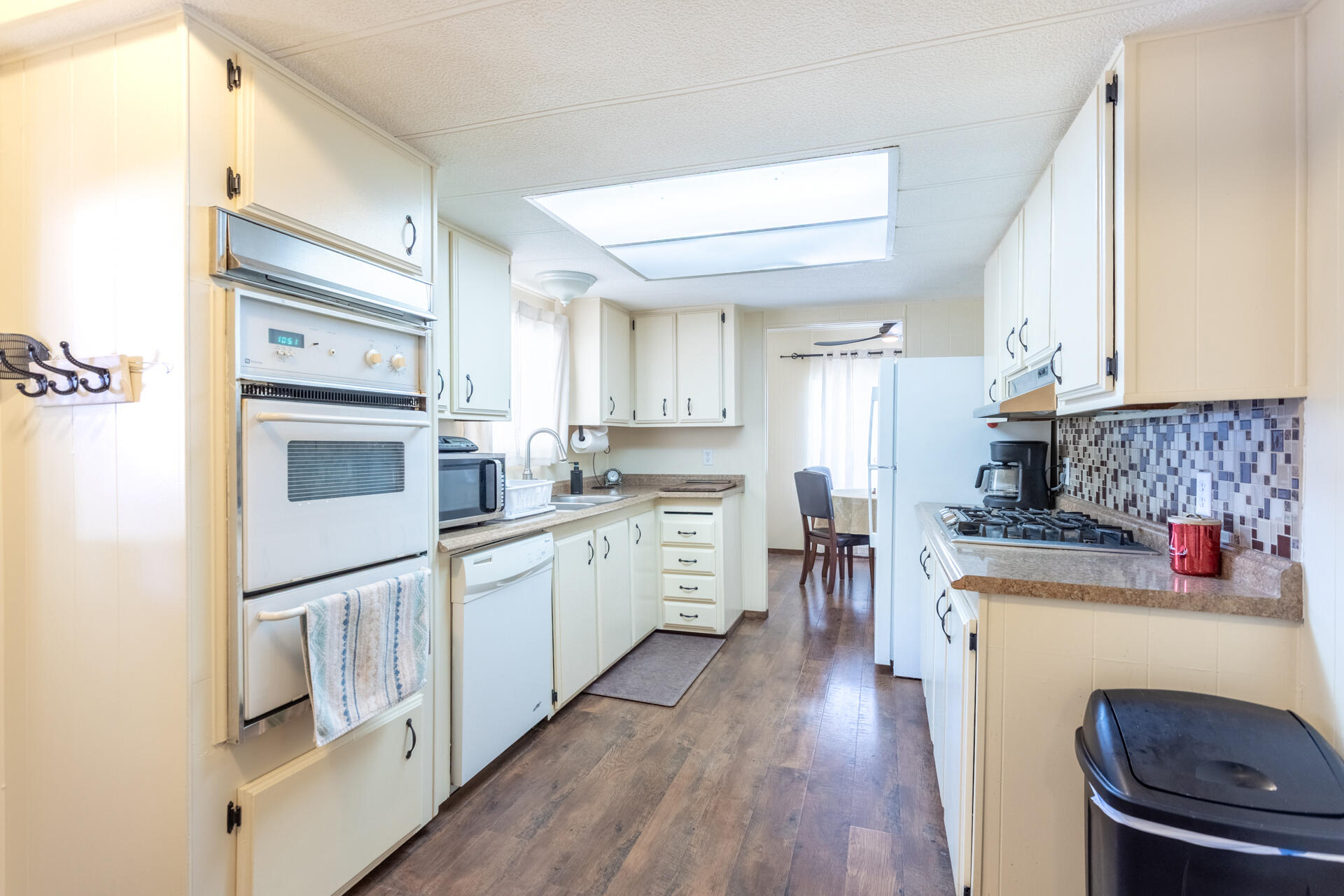 1272 Mountain Shadows Boulevard Redding, CA 96003 - Photo 5 of 22 a kitchen with stainless steel appliances white cabinets and wooden floors