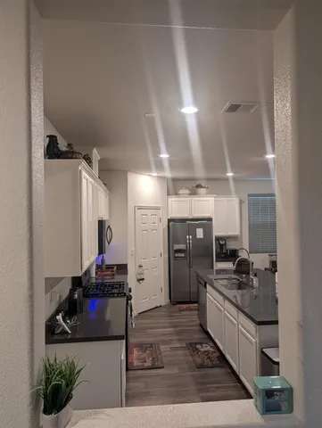 a kitchen with refrigerator and cabinets