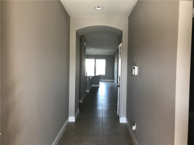 a view of a hallway with wooden floor and a living room