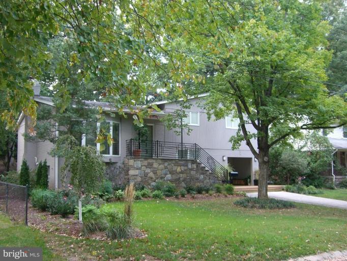 9213 Friars Road Bethesda, MD 20817 - Photo 3 of 15 a front view of a house with a yard and a garden