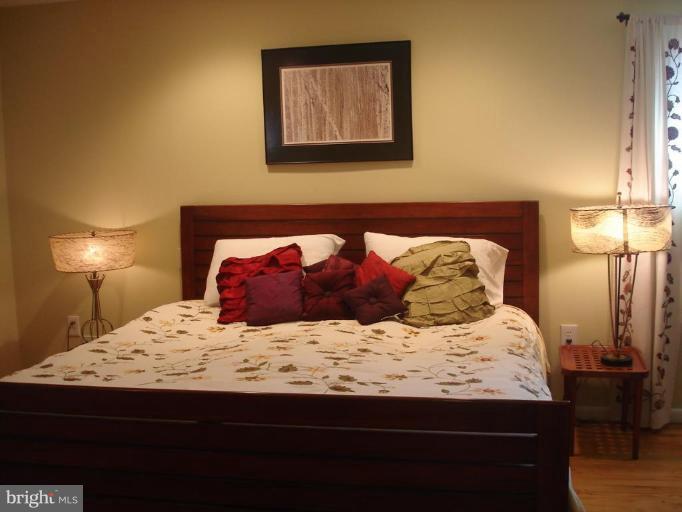 9213 Friars Road Bethesda, MD 20817 - Photo 7 of 15 a bedroom with a bed and a lamp