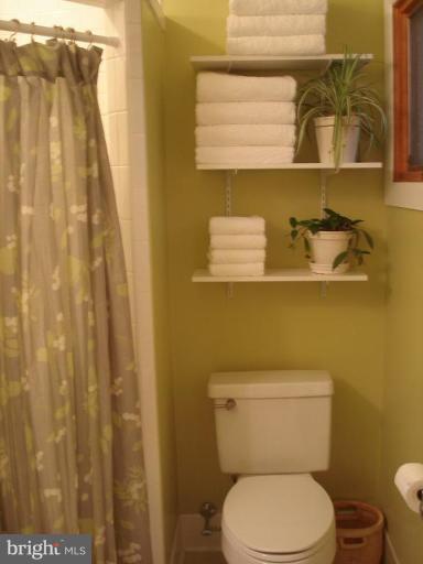 9213 Friars Road Bethesda, MD 20817 - Photo 8 of 15 a white toilet sitting next to a shower curtain