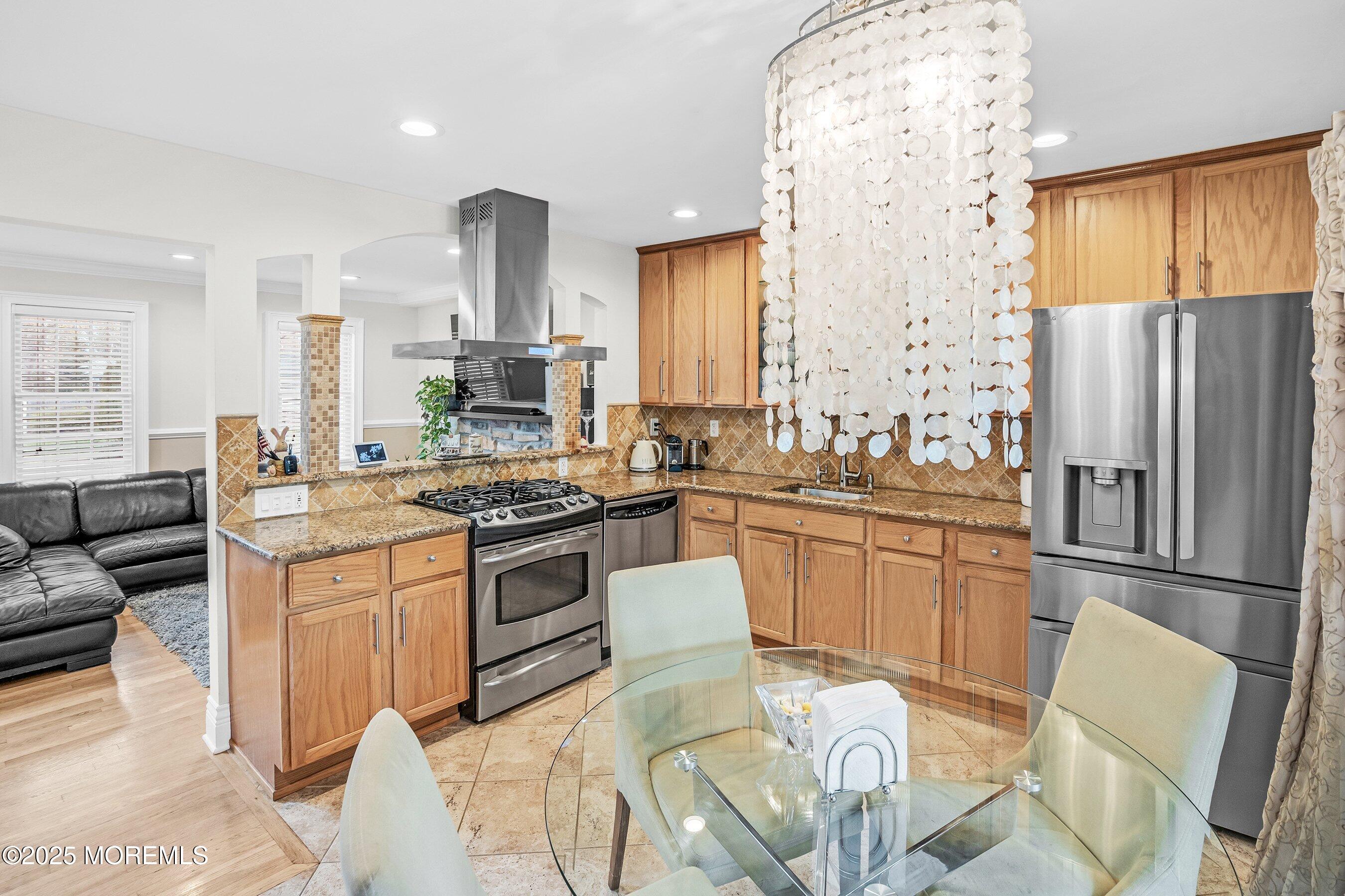 21 Drexel Drive Jackson, NJ 08527 - Photo 9 of 36 a kitchen with stainless steel appliances granite countertop a stove a refrigerator a sink dishwasher with a dining table and chairs