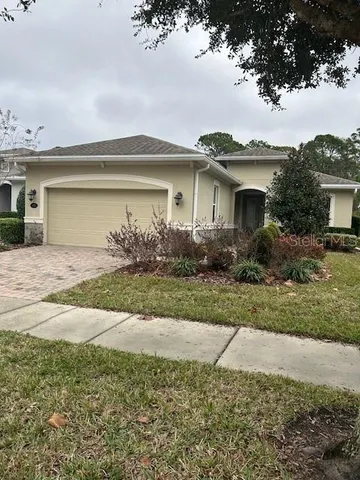 a front view of house with yard and trees around