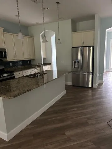 a kitchen with granite countertop a refrigerator and a sink