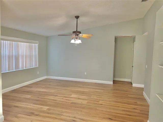 a view of a room with wooden floor fan and window