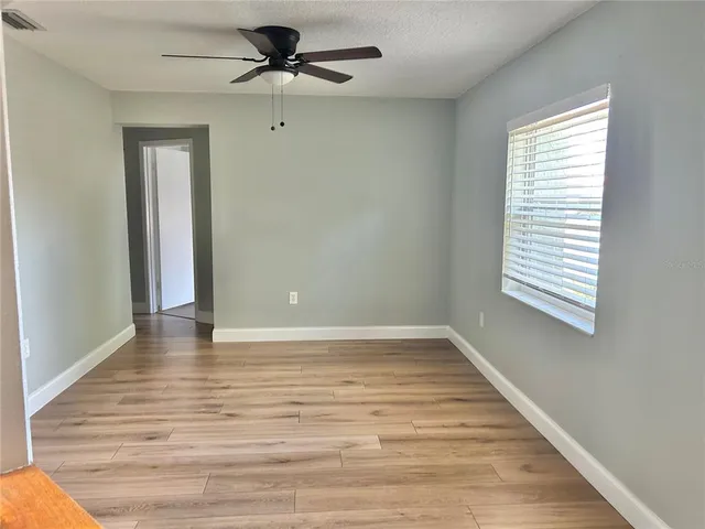 a view of a room with wooden floor and a window