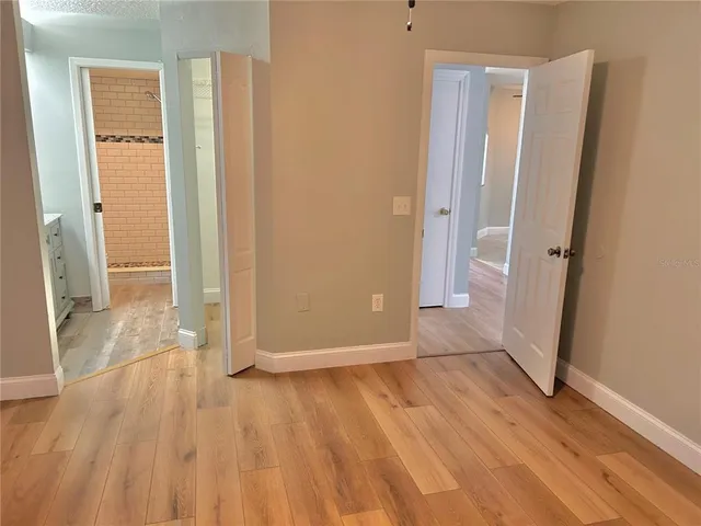 an empty room with wooden floor and entrance