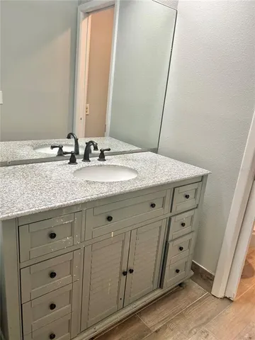 a bathroom with a granite countertop sink and mirror