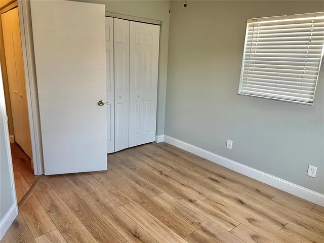 a view of a room with wooden floor and a window