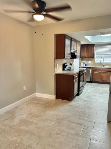 a kitchen with stainless steel appliances granite countertop a sink counter space cabinets and a stove