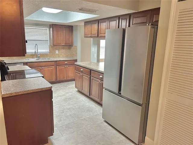 a kitchen with granite countertop a refrigerator and a sink