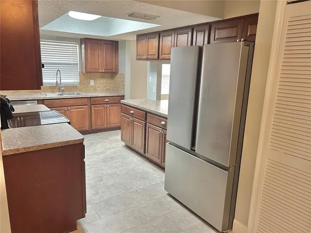 a kitchen with stainless steel appliances granite countertop a refrigerator and a sink