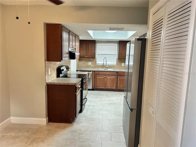 a room with kitchen island a sink a stove and a refrigerator