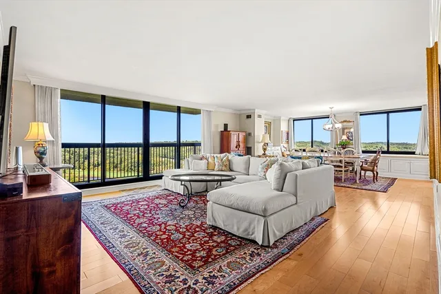 a living room with furniture floor to ceiling window and a table