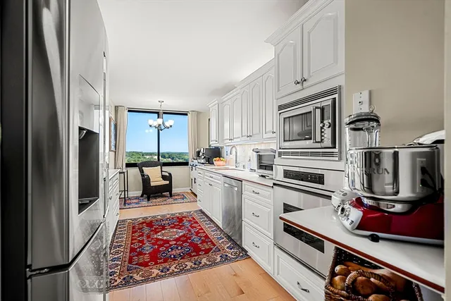 a kitchen with stainless steel appliances granite countertop a refrigerator stove and sink