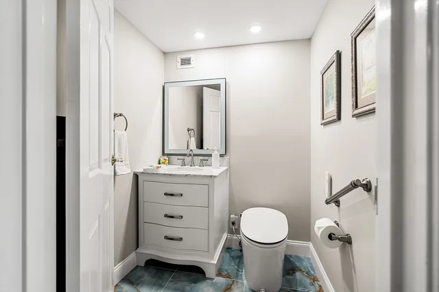 a bathroom with a granite countertop toilet sink and mirror