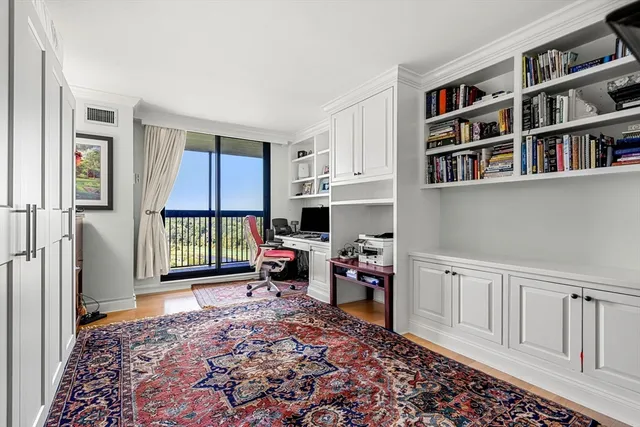 a living room with stainless steel appliances wooden floor and a rug