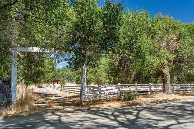 a view of a yard with wooden fence