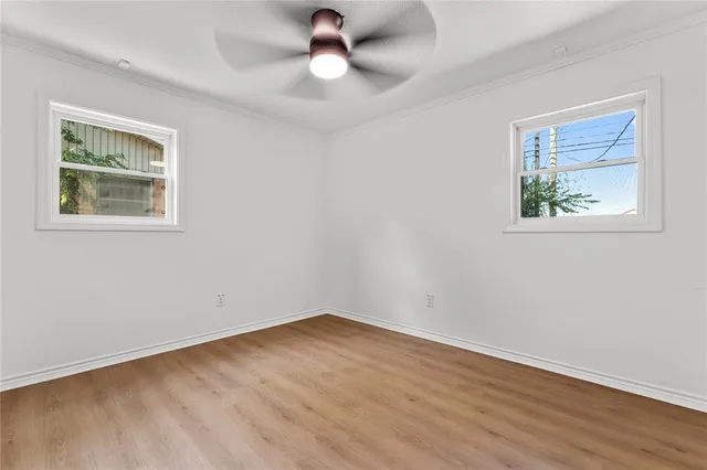 a view of empty room with wooden floor