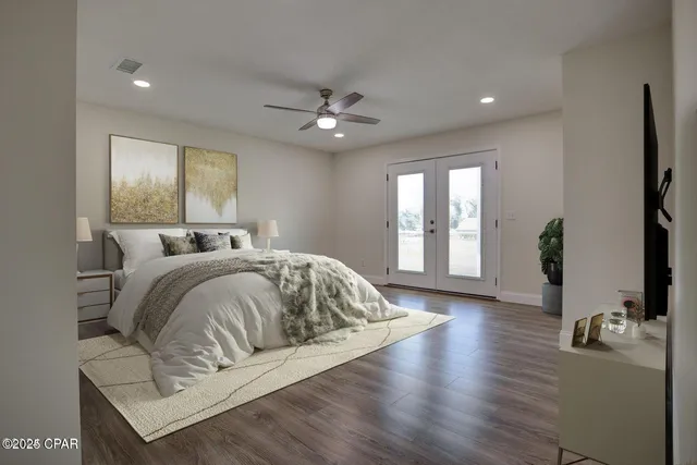 a bed sitting in a spacious bedroom next to a window