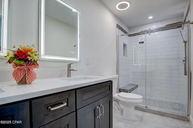 a bathroom with a sink a toilet and shower