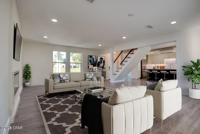 a living room with furniture and a wooden floor