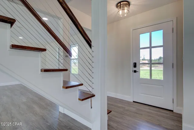 a view of entryway and hall with wooden floor