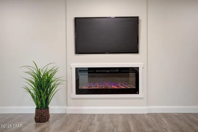 a living room with a fireplace and a potted plant