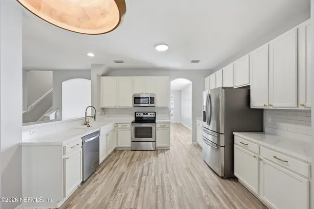 a kitchen with stainless steel appliances a refrigerator sink and cabinets