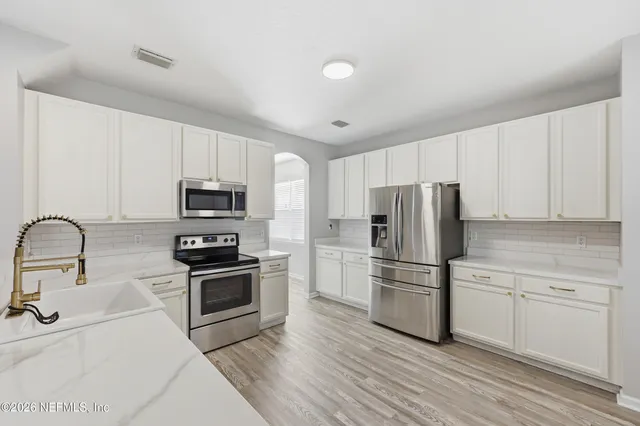 a kitchen with stainless steel appliances a refrigerator stove microwave and sink