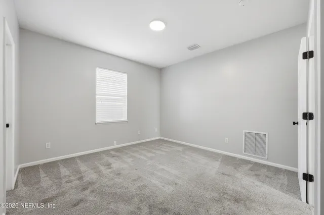 an empty room with windows and closet