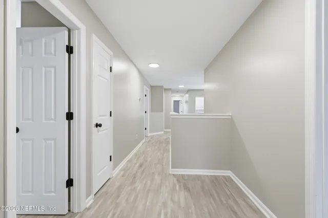 a view of a hallway with wooden floor