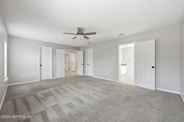 a view of an empty room with a chandelier fan