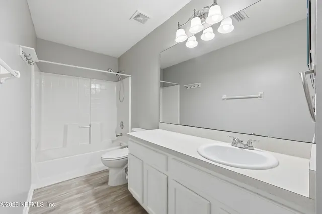 a bathroom with a sink a toilet and a large mirror