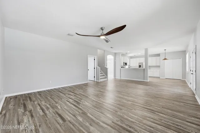 a view of empty room with wooden floor and windows