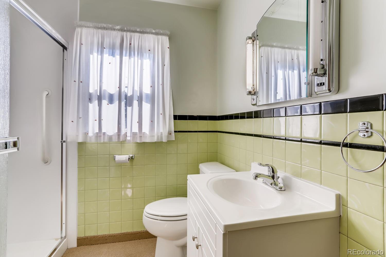 440 South Raleigh Street Denver, CO 80219 - Photo 14 of 29 a bathroom with a sink a toilet and mirror