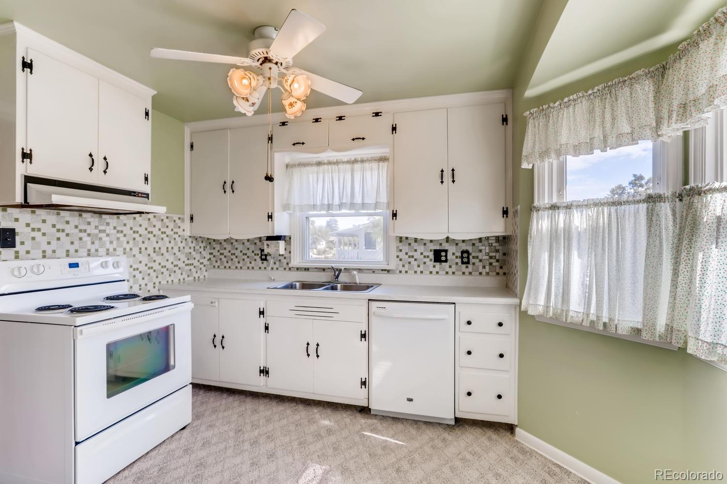 440 South Raleigh Street Denver, CO 80219 - Photo 7 of 29 a kitchen with granite countertop white cabinets white stainless steel appliances with a sink and dishwasher