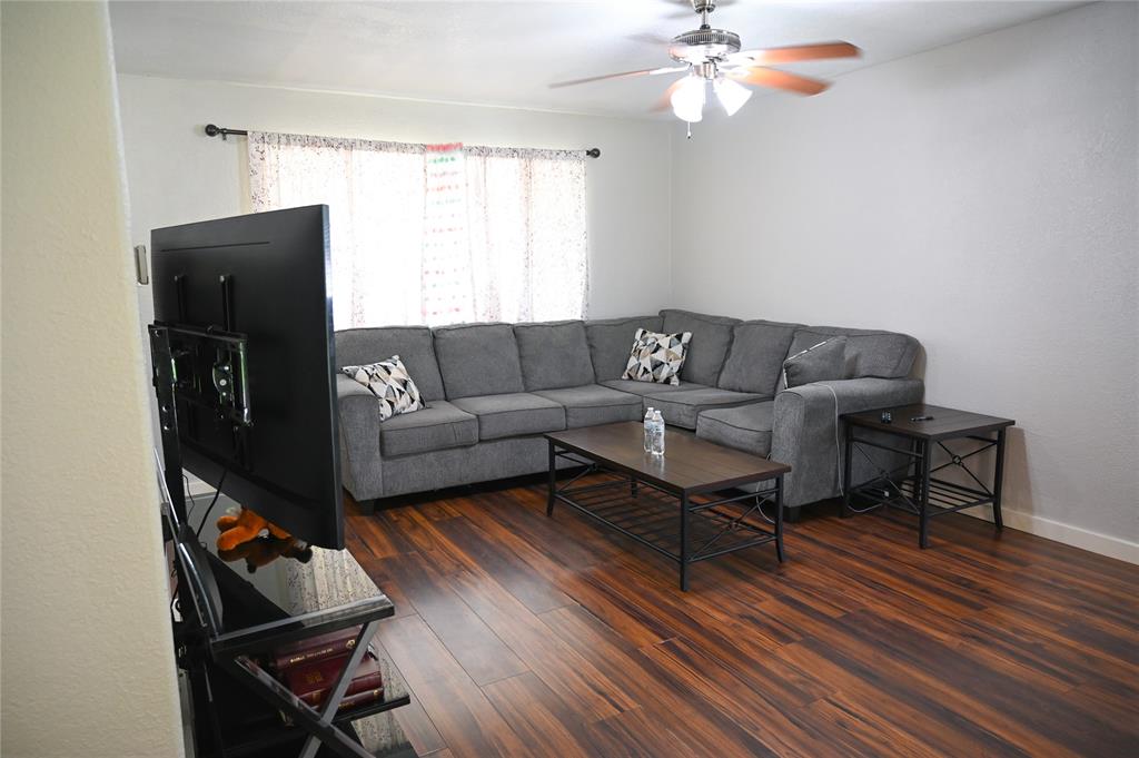 1352 Simpson Drive Hurst, TX 76053 - Photo 17 of 40 Living area featuring rich wood-finish flooring, light-toned walls, and a ceiling fan with integrated lighting
