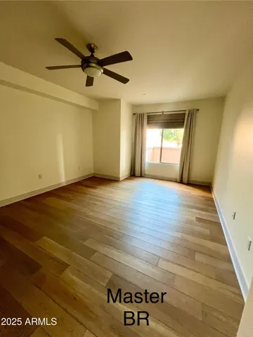 a view of a livingroom with wooden floor and a ceiling fan