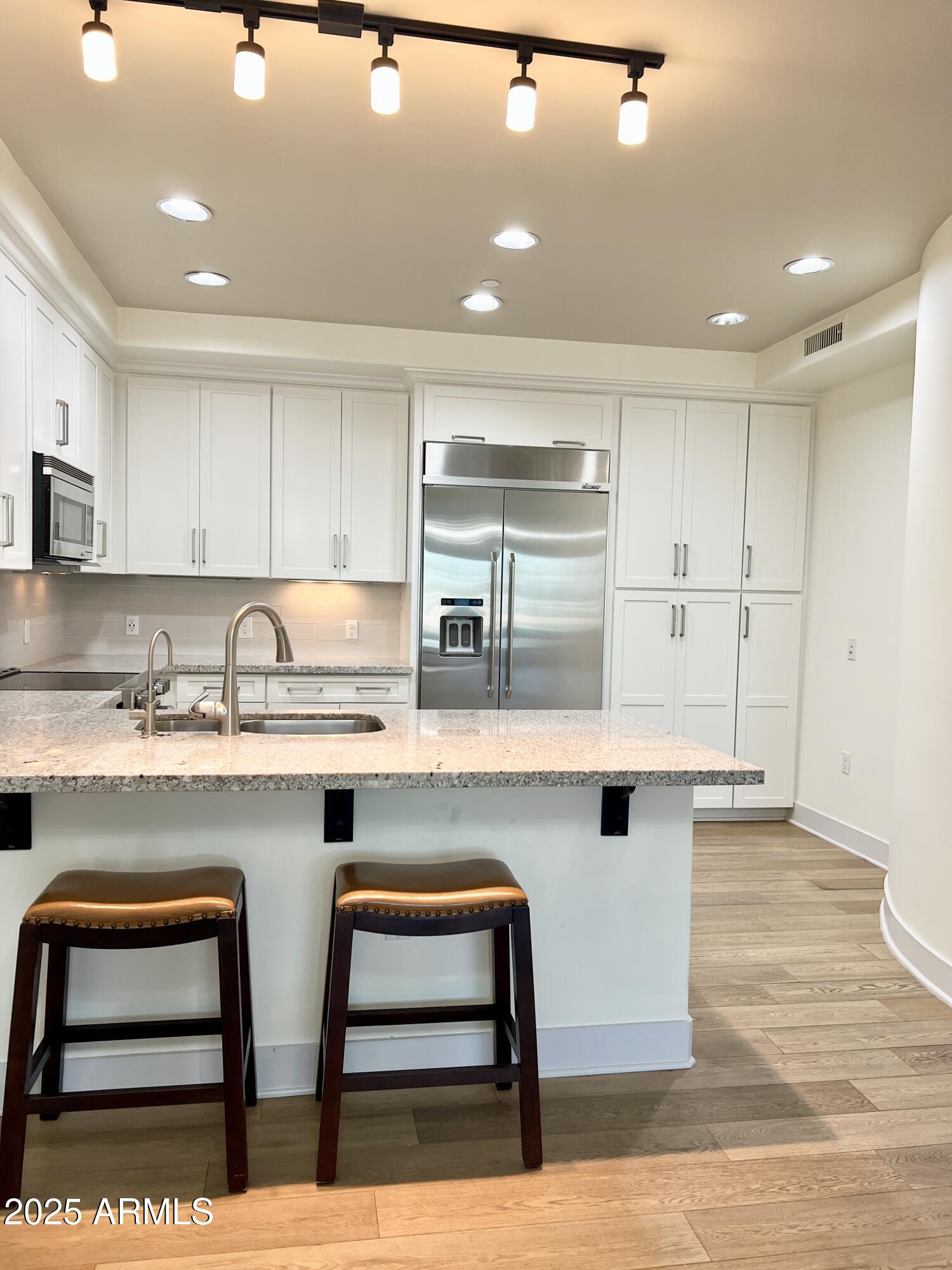 4803 North Woodmere Fairway, Unit 1004 Scottsdale, AZ 85251 - Photo 6 of 21 a kitchen with white cabinets and sink