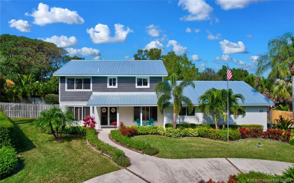 26 Rio Vista Drive Stuart, FL 34996 - Photo 2 of 58 a front view of a house with a garden